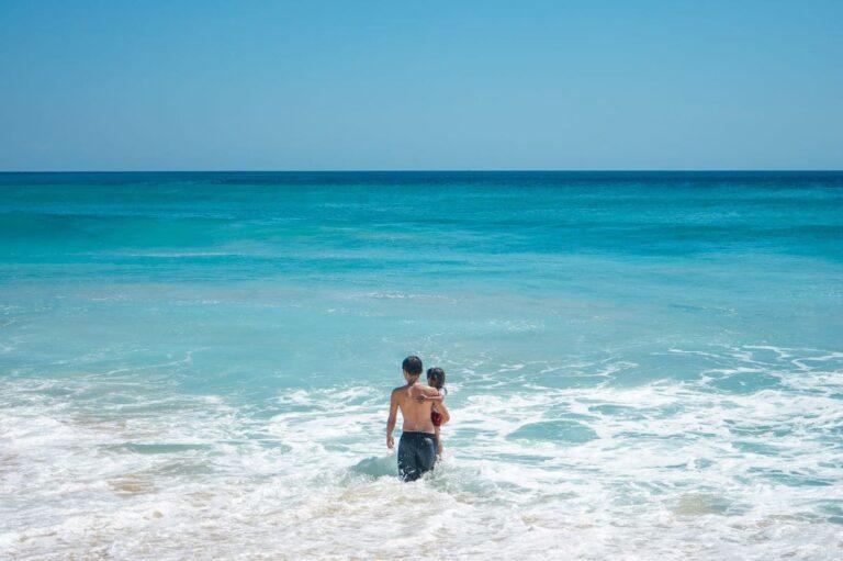 kid-holding-kid-walking-into-ocean